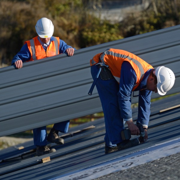 Commercial roofers setting installing metal plates