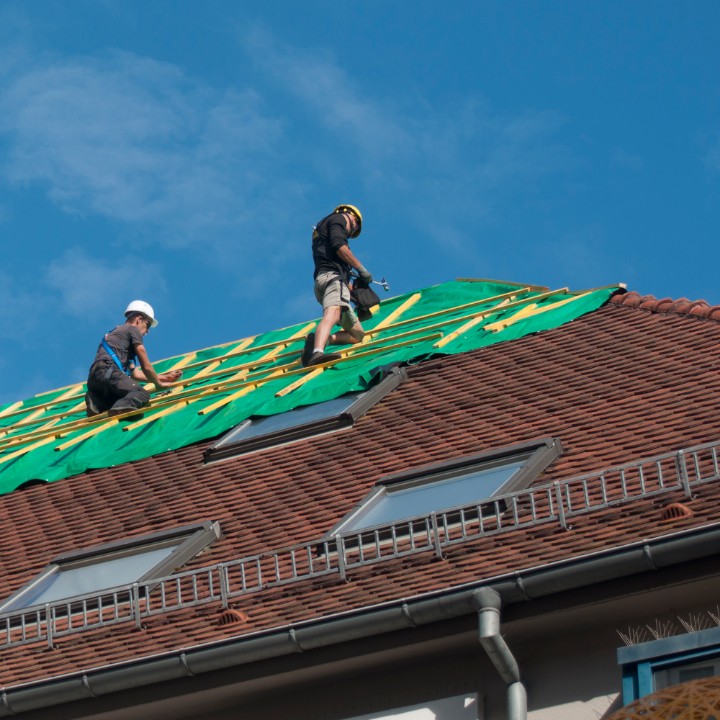 roofers repairing a commercial roof with skylights
